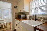 Beautifully restored kitchen with butcher block counters and farmhouse sink 